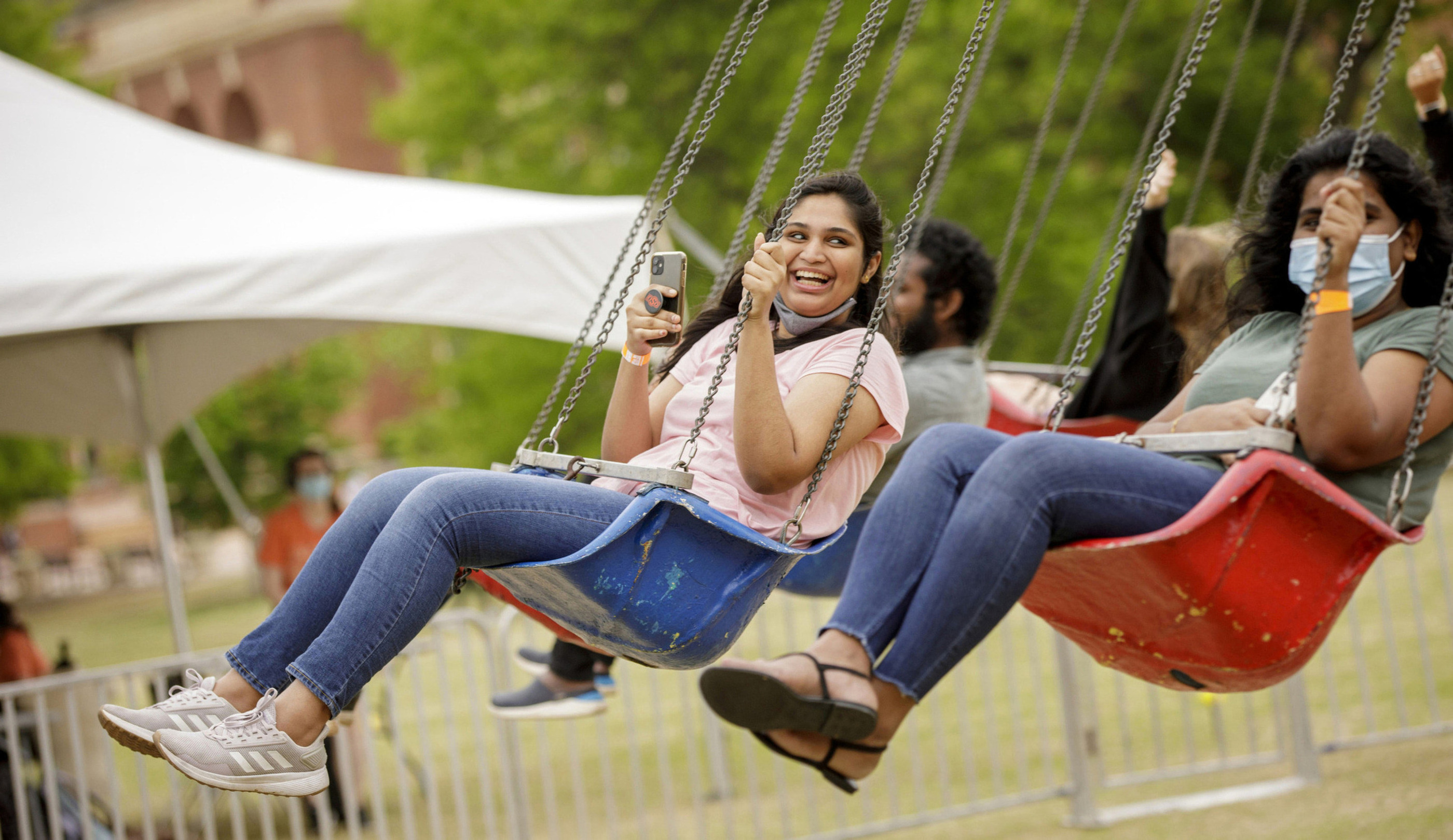 Two people on the swings playing